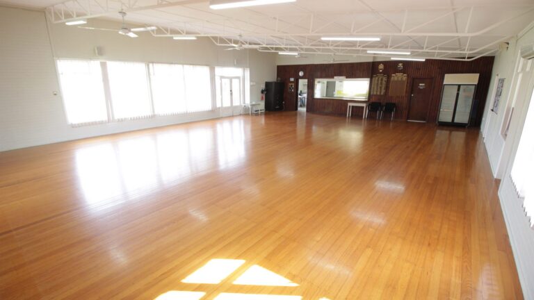 The main hall, empty, with afternoon sun falling across the polished timber floor