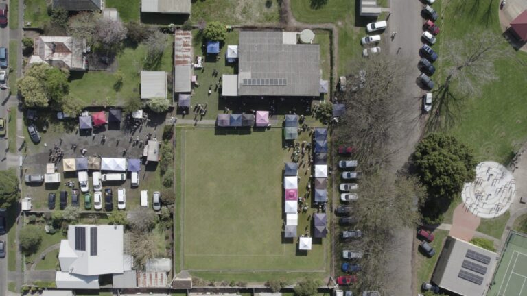 Aerial view of the farmers market filling the green at the Hub, with stalls around all four sides