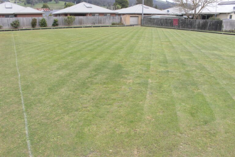 The green at the Hub, freshly mown in stripes, with houses and the Gippsland hills beyond
