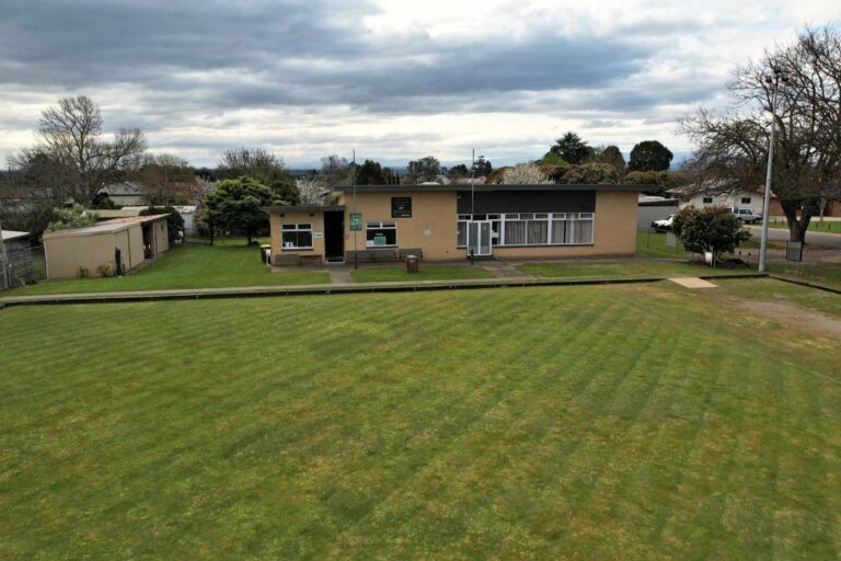 The Trafalgar Park Community Hub and its green seen from the air, with the town behind