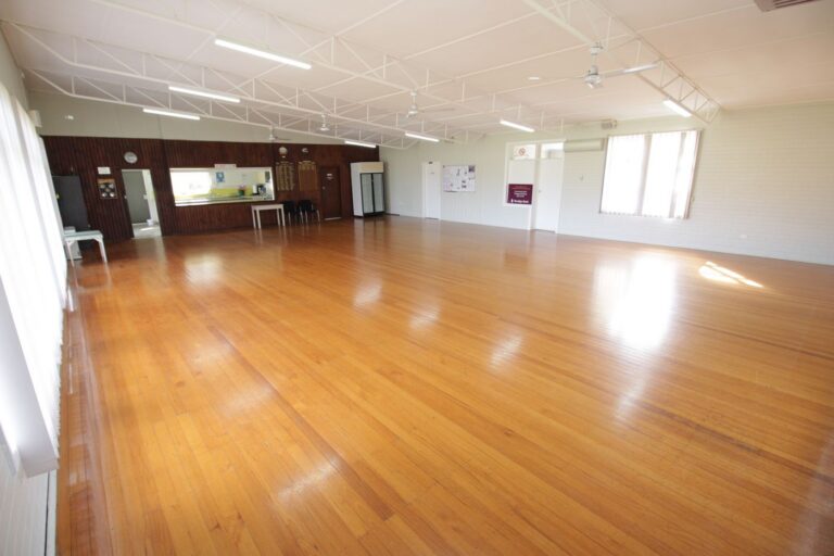 The main hall looking towards the servery hatch, with timber honour boards along the wall