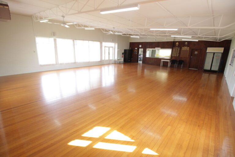 Afternoon sun falling in panels across the polished timber floor of the main hall