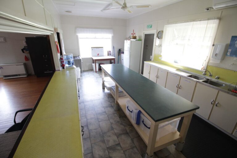 The kitchen's sink and draining area at the end of the long bench