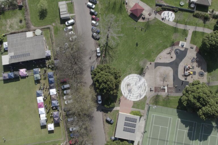 An aerial view showing the Hub and its green beside the public park, playground and tennis courts