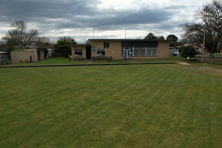 The Hub building seen from across the green, low from the air, with hills behind
